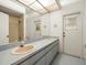 Bathroom features dual sinks, extended vanity, and a shower with glass doors at 13608 Lytton Way, Tampa, FL 33624