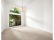 A sunlit bedroom with a large window overlooking lush greenery and soft carpeted floors at 13608 Lytton Way, Tampa, FL 33624