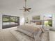 Bright main bedroom featuring a ceiling fan and large sliding doors to the screened patio and pool at 13608 Lytton Way, Tampa, FL 33624