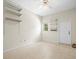 An empty bedroom with a ceiling fan, shelving, a window, and a neutral color scheme at 13608 Lytton Way, Tampa, FL 33624