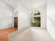 Bright foyer featuring tile flooring, arched windows, and a wooden front door at 13608 Lytton Way, Tampa, FL 33624
