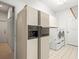 Laundry room with a refrigerator, washer, dryer, cabinets, and a tiled floor at 13608 Lytton Way, Tampa, FL 33624