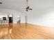 Bright living room with sleek hardwood floors, ceiling fan, and open layout into the kitchen at 13608 Lytton Way, Tampa, FL 33624