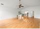 Open-concept living room with hardwood floors, ceiling fan, and access to the kitchen and pool area at 13608 Lytton Way, Tampa, FL 33624