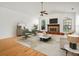 Cozy living room with warm hardwood floors, decorative fireplace, and bright windows offering a welcoming atmosphere at 13608 Lytton Way, Tampa, FL 33624