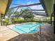Screened-in pool and patio with views of the backyard and surrounding greenery at 13608 Lytton Way, Tampa, FL 33624