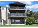 Three-story home with multiple balconies and an outdoor living area and waterfront views at 1402 Harbour Walk Rd, Tampa, FL 33602