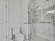 Bathroom featuring a walk-in shower with glass door and decorative tile accents, plus toilet at 1402 Harbour Walk Rd, Tampa, FL 33602
