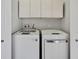 A laundry room is equipped with a modern washer and dryer, with upper cabinets and neutral walls at 1402 Harbour Walk Rd, Tampa, FL 33602