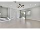 A large empty living room with tiled floors, a ceiling fan, neutral paint, and sliding glass doors for ample natural light at 1402 Harbour Walk Rd, Tampa, FL 33602