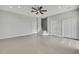A large empty living room with tiled floors, a ceiling fan, neutral paint, and multiple doorways to other parts of the house at 1402 Harbour Walk Rd, Tampa, FL 33602