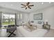 Living room featuring contemporary decor, a ceiling fan, tiled floors, and sliding glass doors that lead to a backyard area at 1402 Harbour Walk Rd, Tampa, FL 33602