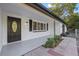 Inviting front porch with a modern door and updated brick accent wall, with tasteful landscaping at 15025 Shark St, Hudson, FL 34667