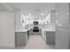 Modern kitchen featuring sleek gray and white cabinets, stainless steel appliances, and updated backsplash at 15025 Shark St, Hudson, FL 34667