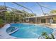 Relax in the refreshing pool surrounded by a screened enclosure and lush landscaping at 15025 Shark St, Hudson, FL 34667
