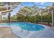 Sparkling pool with a screened enclosure, surrounded by lush landscaping at 15025 Shark St, Hudson, FL 34667