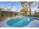 Large in-ground pool with screened enclosure and lush landscaping at 15025 Shark St, Hudson, FL 34667
