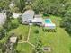 Lush backyard featuring a screened porch, outdoor deck with patio furniture, a sparkling pool, and ample yard space at 1709 Main St, Safety Harbor, FL 34695