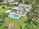 Overhead view of home featuring a pool and firepit, nestled on a lush lot with mature trees at 1709 Main St, Safety Harbor, FL 34695