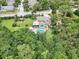 Aerial view showcases a home with a pool, screened in porch, spacious yard, and mature trees in a quiet neighborhood at 1709 Main St, Safety Harbor, FL 34695