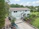 Expansive aerial view of a two-story home featuring an attached garage, lush yard, and golf cart parking on a paved driveway at 1709 Main St, Safety Harbor, FL 34695