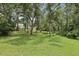 Secluded backyard view with lush green grass and mature trees, offering a private and serene outdoor setting at 1709 Main St, Safety Harbor, FL 34695