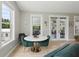 Cozy dining area with a marble table, green chairs, and natural light with views to the outside at 1709 Main St, Safety Harbor, FL 34695