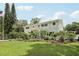 Beautiful two-story home showcasing meticulously landscaped grounds, lush greenery, and a well-manicured lawn at 1709 Main St, Safety Harbor, FL 34695