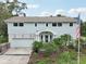 Inviting two-story home with lush front yard landscaping, an attached garage and a charming covered front porch at 1709 Main St, Safety Harbor, FL 34695