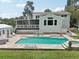 Outdoor living at its finest: a stunning pool with a spa, complemented by an inviting screened patio and seating area at 1709 Main St, Safety Harbor, FL 34695