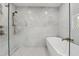 Modern shower featuring a glass enclosure, hexagon floor tiles, and a luxurious bathtub at 1709 Main St, Safety Harbor, FL 34695