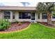 Lush backyard with a palm tree, well-maintained lawn, and a charming brick-lined flower bed at 18531 Bent Pine Dr, Hudson, FL 34667