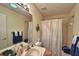 Bright bathroom featuring a vanity with a neutral-toned sink and a shower with patterned curtains at 18531 Bent Pine Dr, Hudson, FL 34667