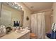 Bright bathroom featuring a vanity with a neutral-toned sink and a shower with patterned curtains at 18531 Bent Pine Dr, Hudson, FL 34667