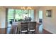 Bright dining room features a rustic table, modern chandelier, and sliding glass doors to the outdoor patio at 18531 Bent Pine Dr, Hudson, FL 34667