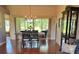 Bright dining room features a rustic table, modern chandelier, and sliding glass doors to the outdoor patio at 18531 Bent Pine Dr, Hudson, FL 34667