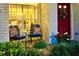 Inviting front porch featuring a bright red door with a wreath, seating, and manicured landscaping at 18531 Bent Pine Dr, Hudson, FL 34667