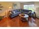 Comfortable living room featuring an L-shaped sofa, warm lighting, and a view of the exterior landscape at 18531 Bent Pine Dr, Hudson, FL 34667
