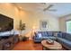 Cozy living room with vaulted ceilings, a ceiling fan, and a comfortable blue sofa at 18531 Bent Pine Dr, Hudson, FL 34667