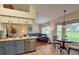 Bright living room with adjacent kitchen featuring an L-shaped sofa and views to the exterior landscape at 18531 Bent Pine Dr, Hudson, FL 34667