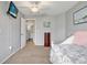 Bright bedroom featuring soft carpet and easy access to a well-lit bathroom and other rooms at 18702 Van Nuys Cir, Port Charlotte, FL 33948