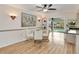 A dining area with a ceiling fan offers hardwood floors and pool views with access to the kitchen at 18702 Van Nuys Cir, Port Charlotte, FL 33948