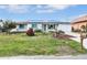 The front of this well-kept home features a manicured lawn, solar panels, and an attached garage at 18702 Van Nuys Cir, Port Charlotte, FL 33948