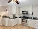 A well-equipped kitchen features stainless steel appliances, light cabinetry, granite countertops, and hardwood floors at 18702 Van Nuys Cir, Port Charlotte, FL 33948