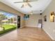 Living room with wood floors, ceiling fans, and sliding doors to the screened lanai at 18702 Van Nuys Cir, Port Charlotte, FL 33948