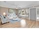 A lovely living room offers hardwood floors, a white sofa set, and natural lighting with neutral-toned walls at 18702 Van Nuys Cir, Port Charlotte, FL 33948
