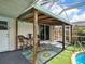 Cozy covered patio with a colorful rug, bar seating, and poolside access for relaxed outdoor enjoyment at 18702 Van Nuys Cir, Port Charlotte, FL 33948