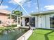 Screened in patio features a tranquil pond with a fountain, creating a relaxing and serene outdoor space at 18702 Van Nuys Cir, Port Charlotte, FL 33948
