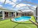 Covered pool with artificial grass and a lanai, perfect for outdoor relaxation and entertaining at 18702 Van Nuys Cir, Port Charlotte, FL 33948