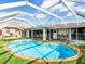 Backyard pool with covered lanai, artificial turf, and outdoor seating area at 18702 Van Nuys Cir, Port Charlotte, FL 33948